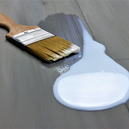 lacquer being applied to grey floorboards
